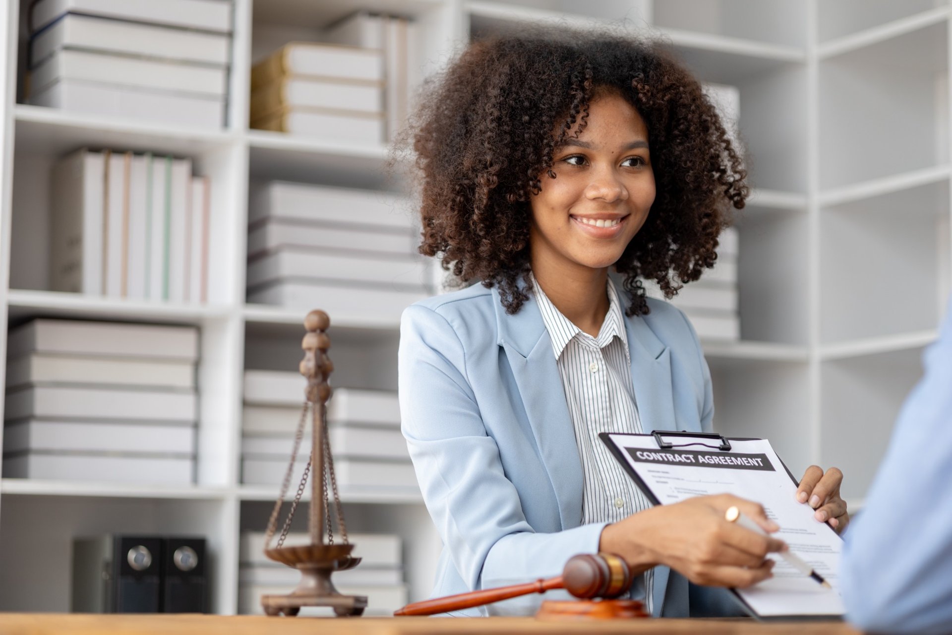 Attorney showing a contract agreement across the desk in a law office