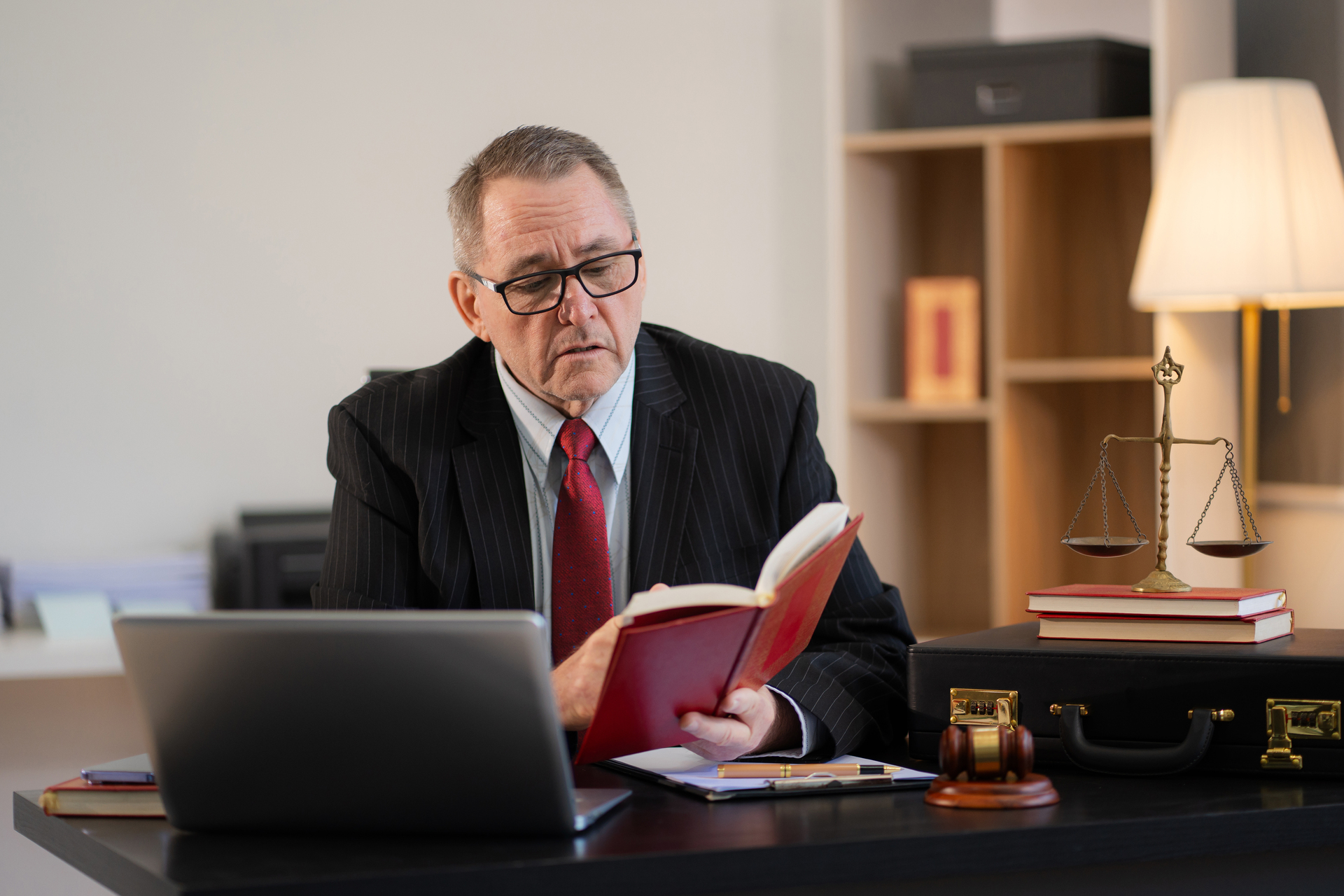 Serious lawyer working at desk in office reading