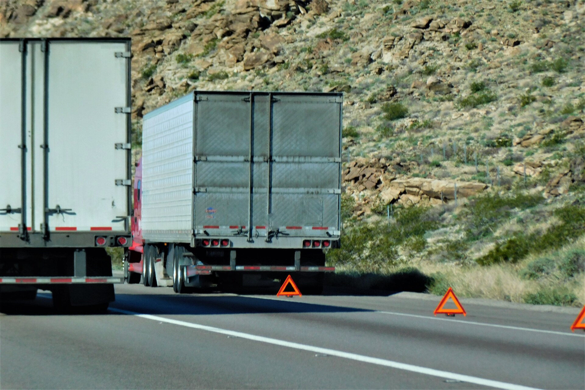 Two big white trucks on highway