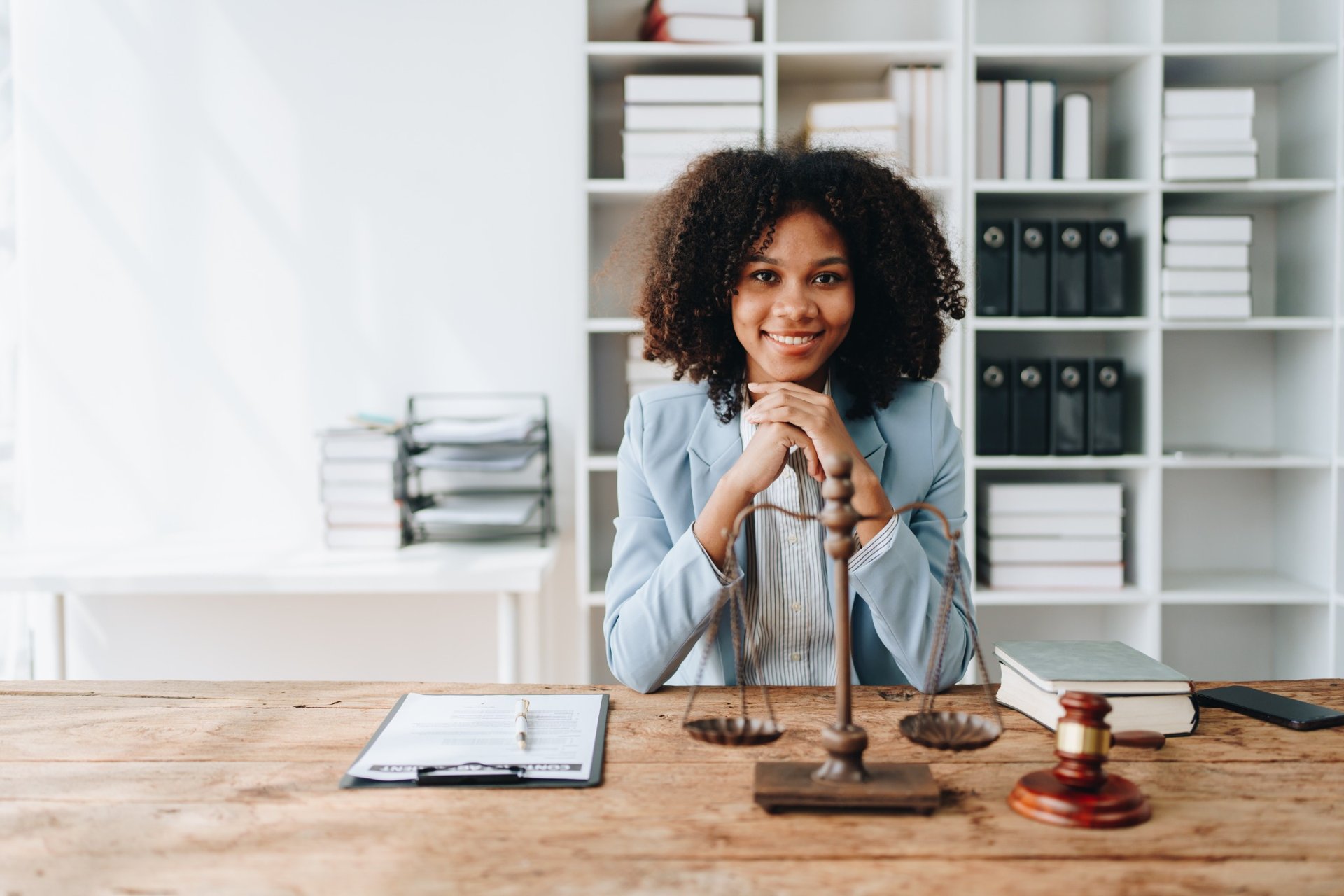 Confident female lawyer sitting at her desk with legal documents